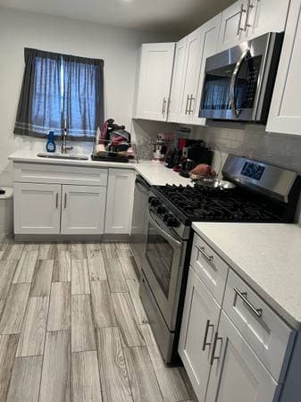 picture of a newly remodeled bathroom with gray stonework and dual luxury sinks and marble countertops